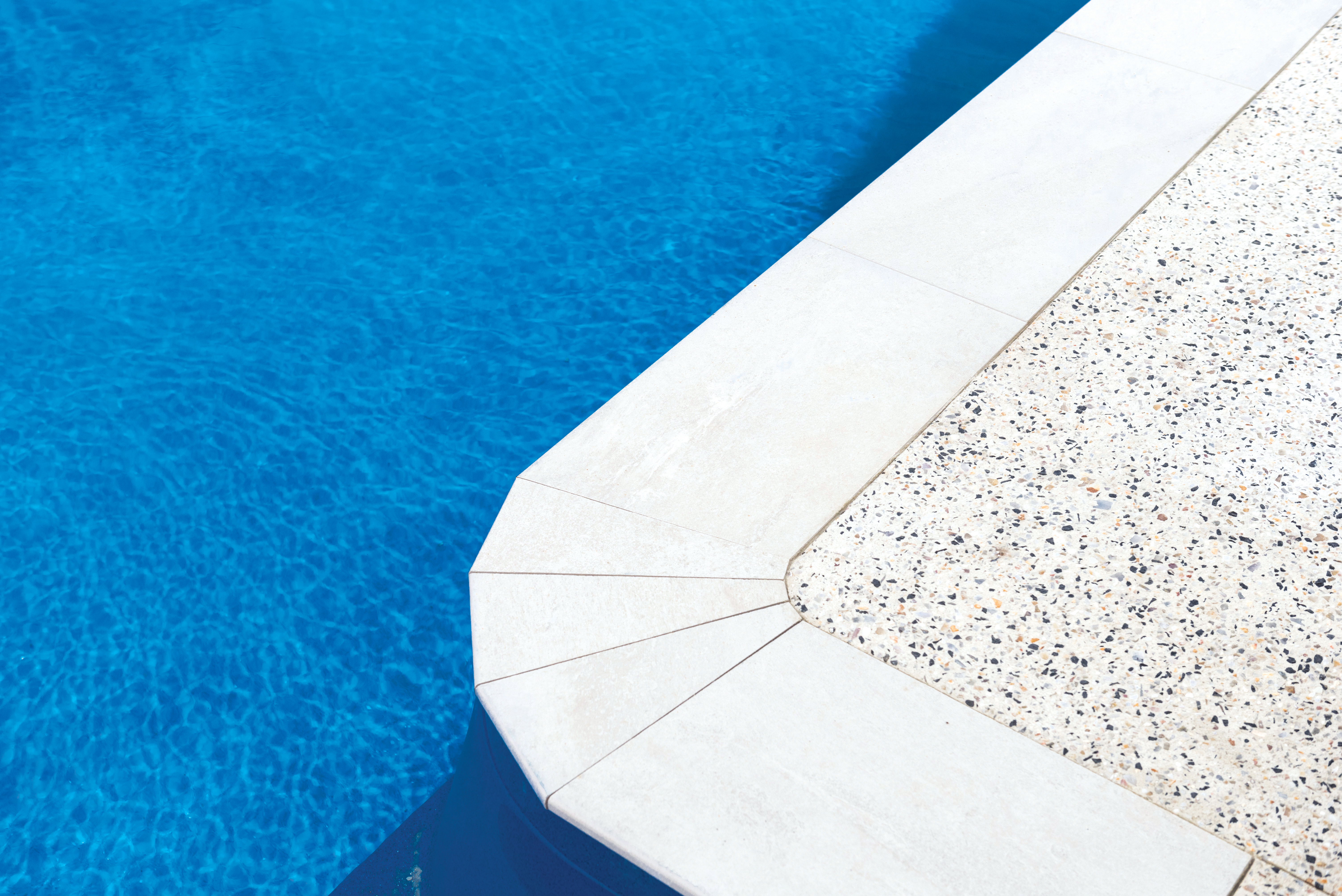 Exposed aggregate concrete by pools edge