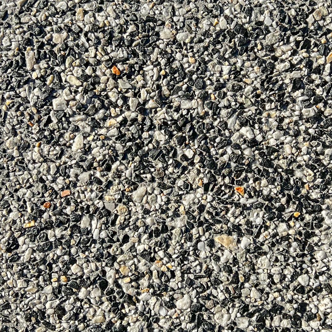 Close up swatch of concrete with exposed aggregates in the shade Eclipse