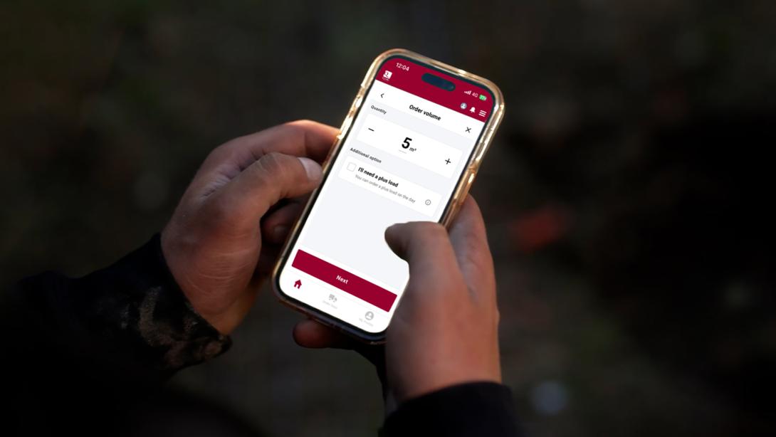 Mobile phone in hand showing Q-crete concrete app